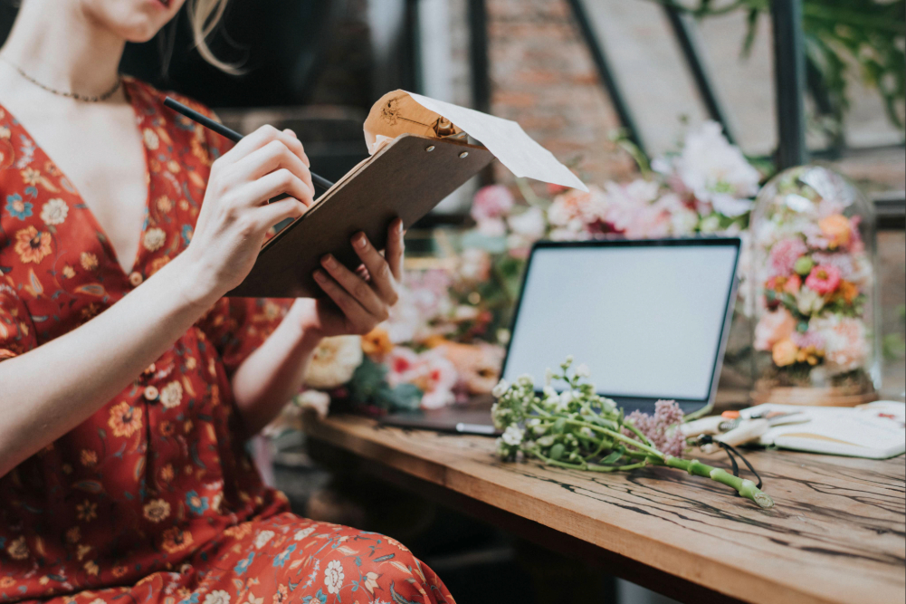 Wedding Planner working with flowers and a laptop at a table.